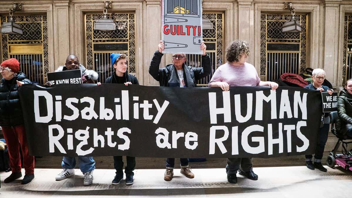 Picture of protesters holding sign reading disability rights are human rights