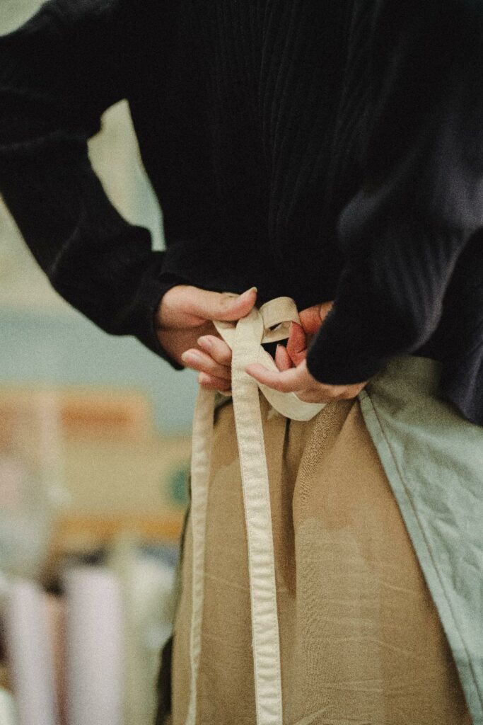 Person tying an apron in back